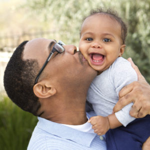 Dad kissing baby