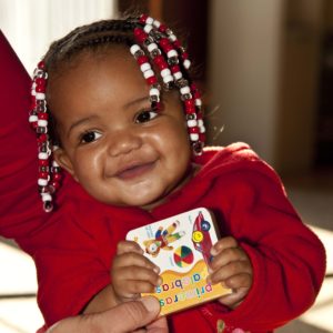 Baby with book & mom by her side